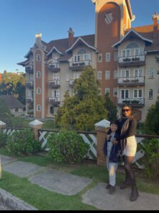 Mãe e filho em frente à casa da Vila Holandesa em Campos do Jordão durante viagem em família