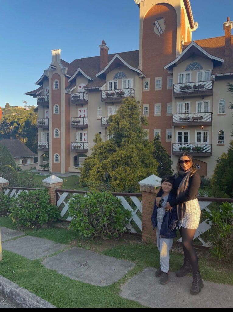 Mãe e filho em frente à casa da Vila Holandesa em Campos do Jordão durante viagem em família