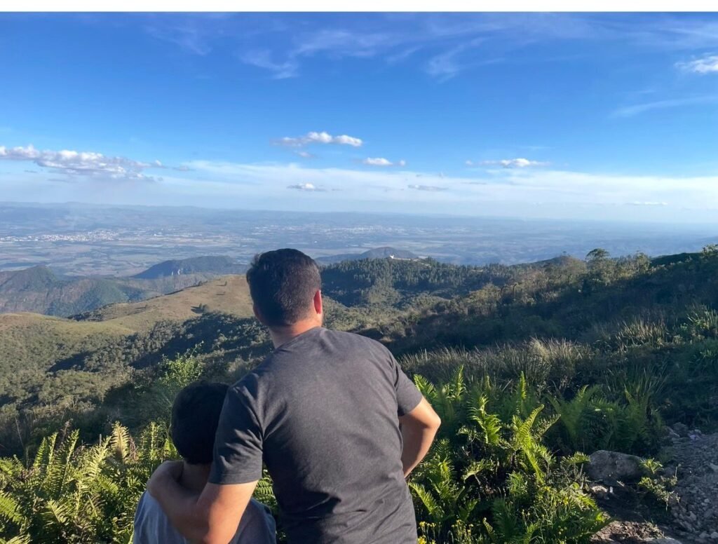 Pai e filho admirando a vista do Pico do Itapeva em Campos do Jordão durante viagem em família