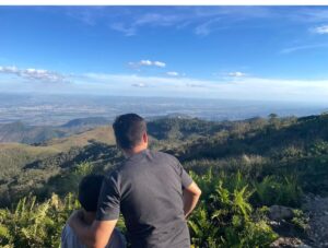 Pai e filho admirando a vista do Pico do Itapeva em Campos do Jordão durante viagem em família
