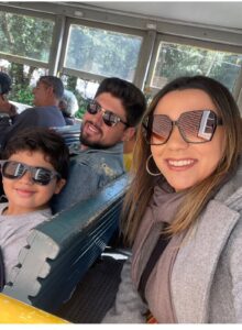 Família com dois adultos e uma criança dentro do bondinho turístico de Campos do Jordão durante passeio pela cidade