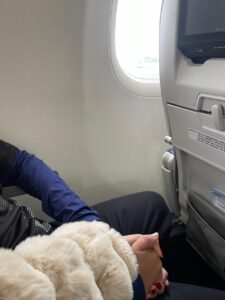 Mãe segurando a mão do filho durante voo ao viajar de avião com criança autista