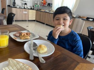 Lucas tomando café da manhã no Hotel Tarobá durante nossa viagem em família para Foz do Iguaçu.