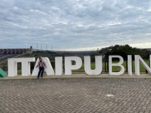 Lucas posando em frente ao letreiro da Itaipu Binacional durante passeio em Foz do Iguaçu.