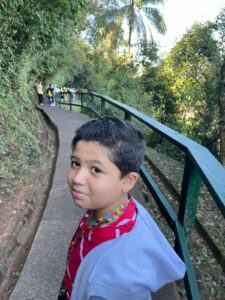 Lucas no início da trilha das Cataratas do Iguaçu, cercado pela natureza durante passeio em família em Foz do Iguaçu.