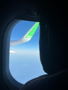 Rafael olhando a asa do avião pela janela durante voo com passagem aérea promocional para Santiago