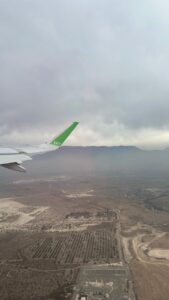 Passagem aérea promocional para Santiago durante voo da Sky Airline com vista da asa do avião