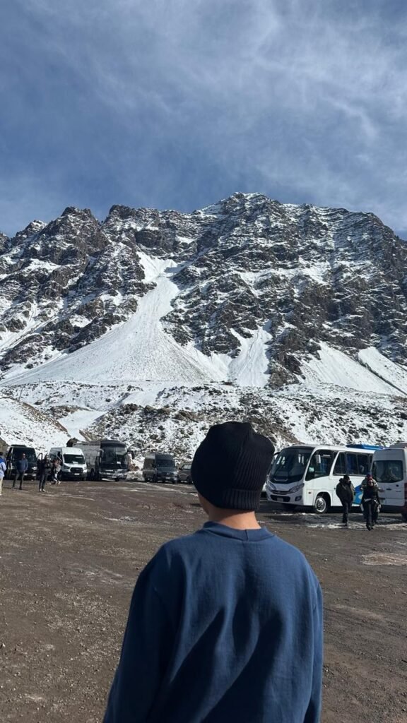 Estações de Ski no Chile: Qual Escolher em 2026? 2 Menino observando as montanhas cobertas de neve em Portillo, uma das mais famosas estações de esqui Chile.