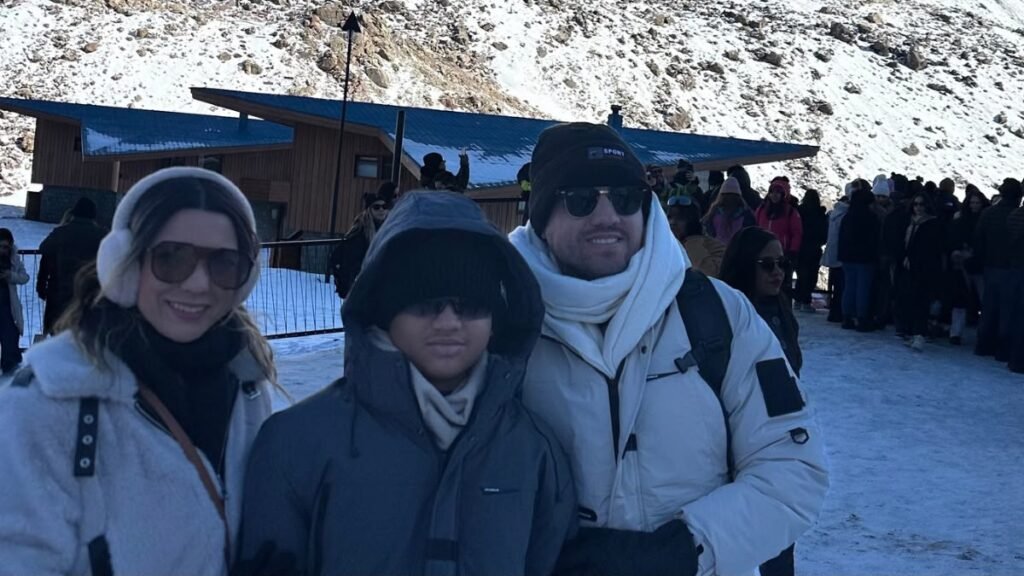 Família em Portillo, no Chile, com muitos visitantes ao fundo