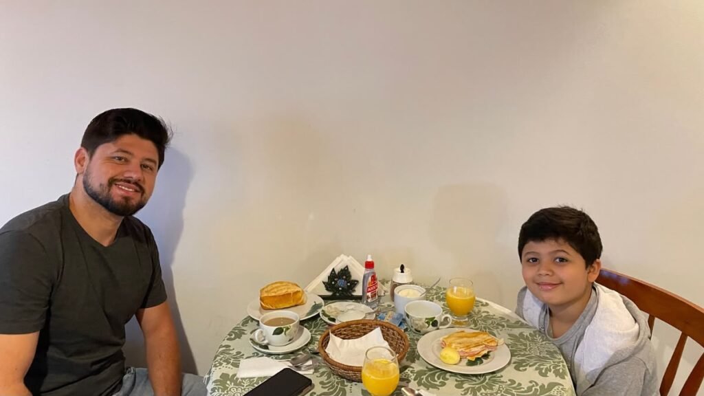 Hospedagem para pessoas autistas: como escolher entre hotel ou Airbnb 3 Rafael e Lucas tomando café da manhã em um hotel