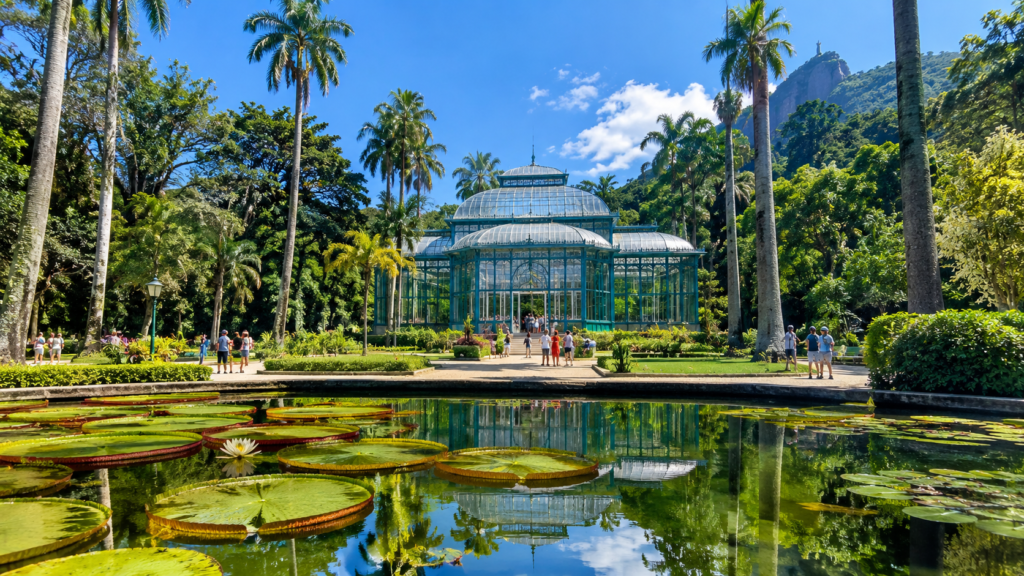 Rio de Janeiro em família no Jardim Botânico, com palmeiras, lago de vitórias-régias e o antigo jardim de inverno ao fundo