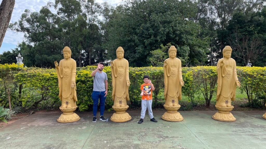 Rafa e Lucas em frente às estátuas budistas do Templo Budista em Foz do Iguaçu