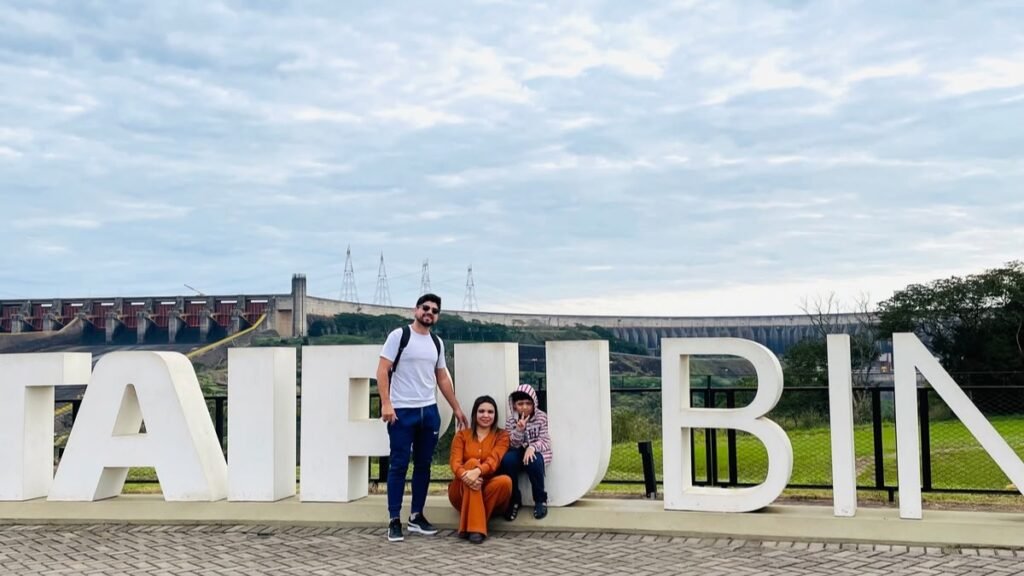 Família no letreiro de Itaipu Binacional durante viagem a Foz do Iguaçu
