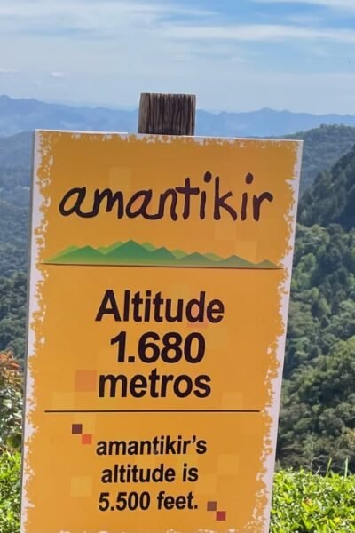 Placa do Parque Amantikir com indicação da altitude de 1.680 metros e vista das montanhas de Campos do Jordão