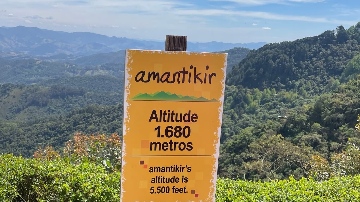 Parque Amantikir: vale a pena? 1 Placa do Parque Amantikir com indicação da altitude de 1.680 metros e vista das montanhas de Campos do Jordão