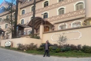 Mãe e filho em frente a um hotel durante uma viagem em família