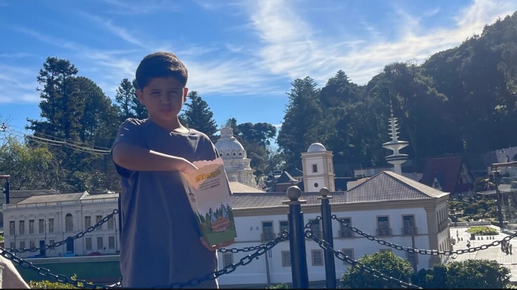 Lucas segura uma embalagem de pipoca durante a visita ao Mini Mundo Gramado.