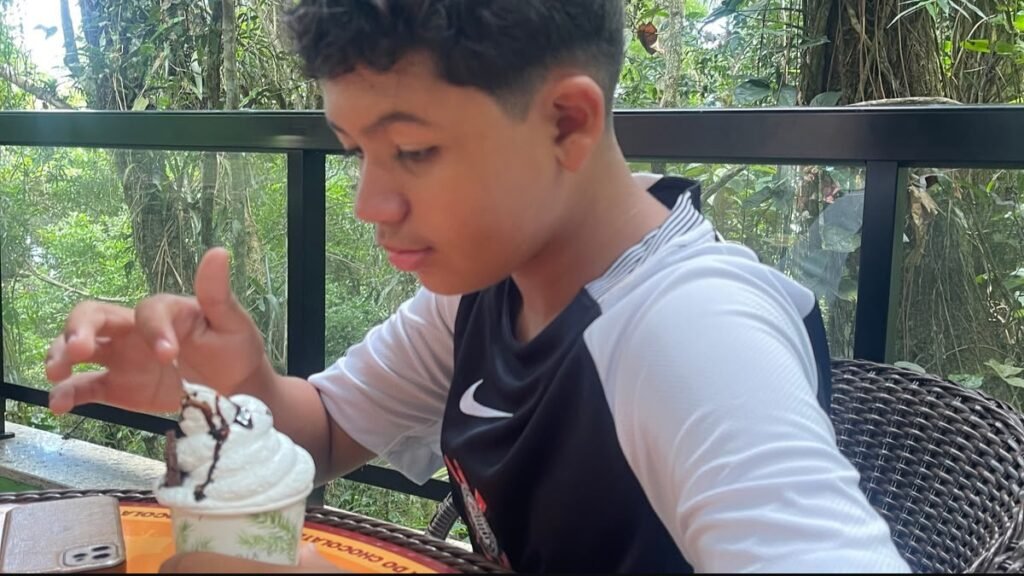 Lucas tomando uma sobremesa de chocolate durante a visita ao Parque Unipraias, em Balneário Camboriú.