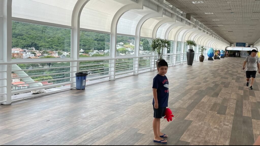 Passeios gratuitos em Balneário Camboriú: Lucas caminhando pela Passarela da Barra Sul, em Santa Catarina.
