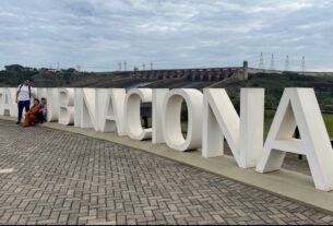 Família posa junto às letras Itaipu Binacional durante a visita à usina