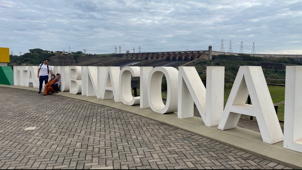 Família posa junto às letras Itaipu Binacional durante a visita à usina