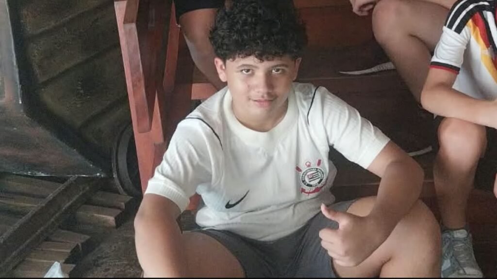 Lucas sentado em um ambiente temático durante a excursão escolar ao Acampark em Charqueada.