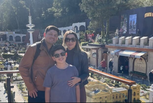 Família reunida no Mini Mundo Gramado, com construções em miniatura ao fundo.