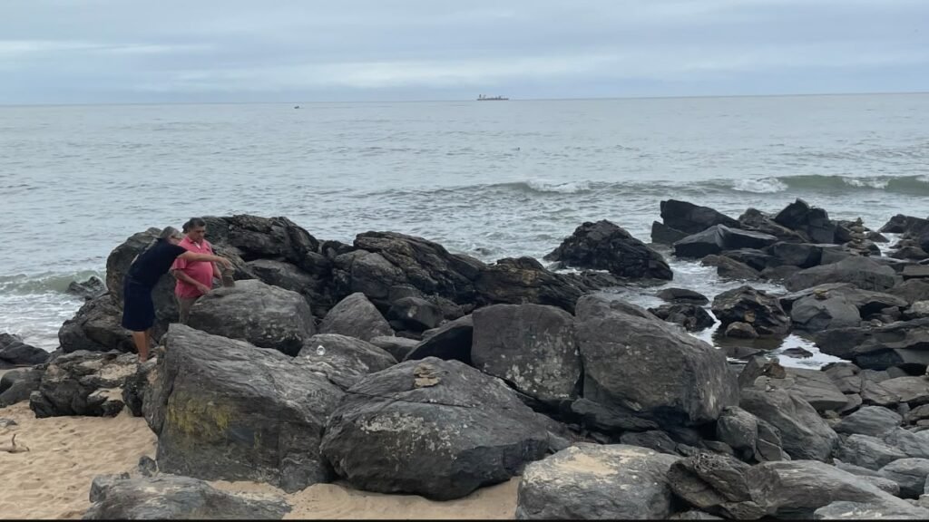 Passeios gratuitos em Balneário Camboriú: meu pai e minha mãe explorando as rochas à beira-mar na Praia do Buraco.