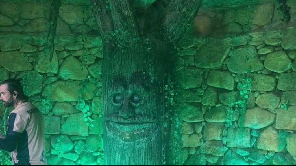Árvore cenográfica em ambiente de pedra iluminado em verde no Acampark em Charqueada.