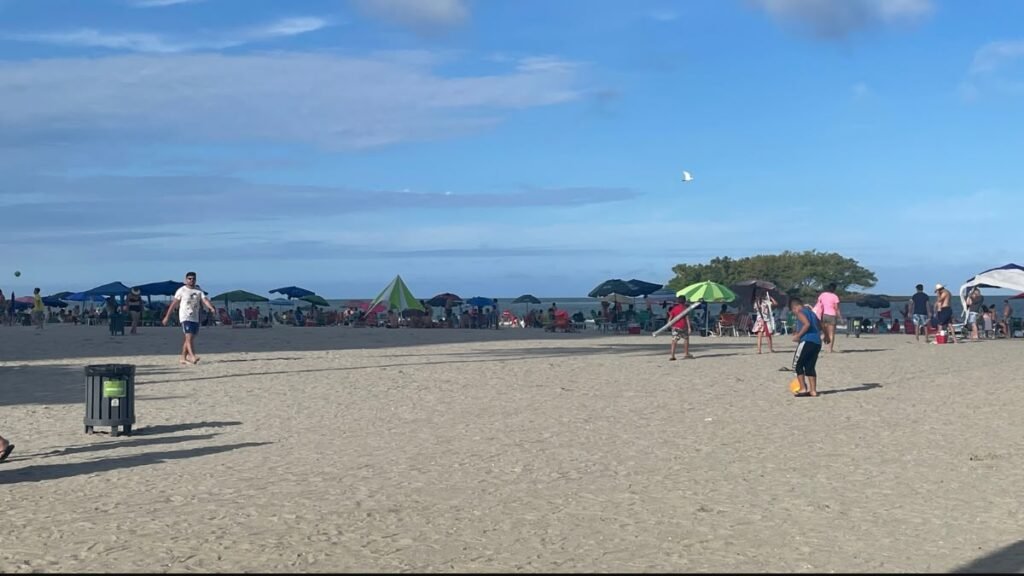 Faixa de areia e guarda-sóis na Praia Central de Balneário Camboriú durante passeio em família.