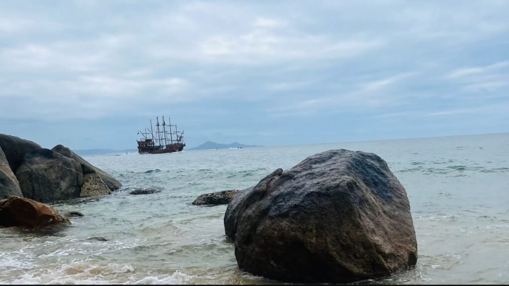 Passeios gratuitos em Balneário Camboriú: vista da Praia de Laranjeiras com navio ao fundo.