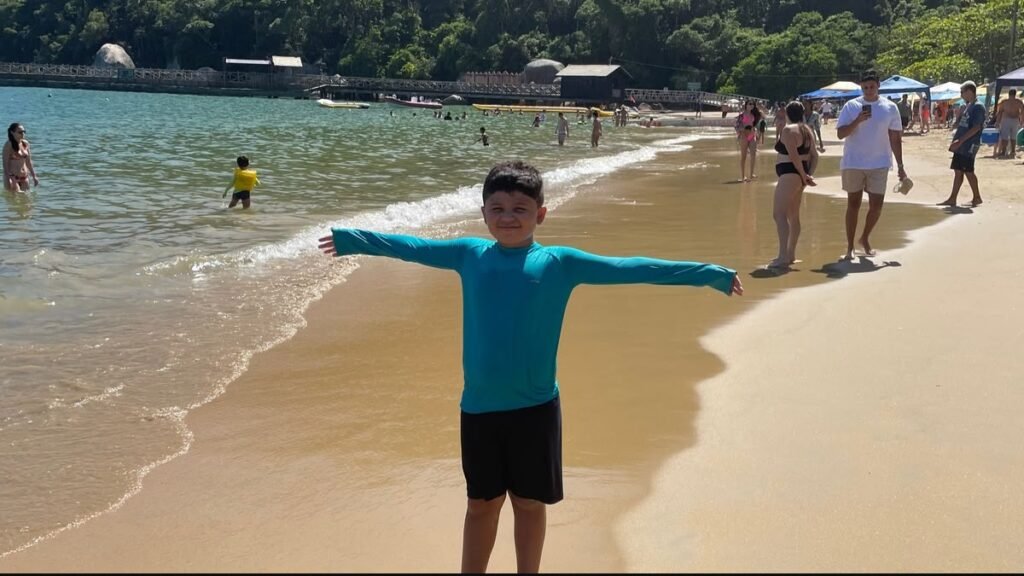 Criança aproveita a água na Praia de Laranjeiras em Balneário Camboriú em família