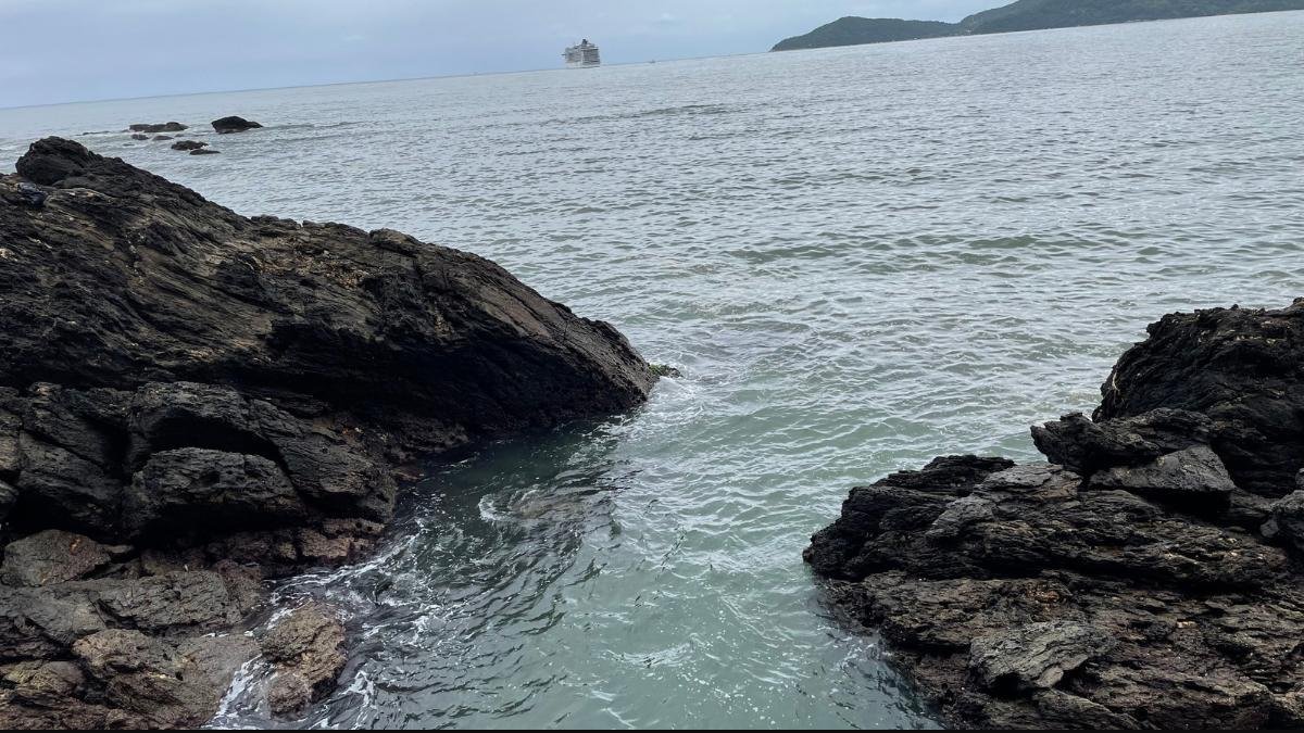 Praia de Laranjeiras, em Balneário Camboriú, com mar e céu nublado.